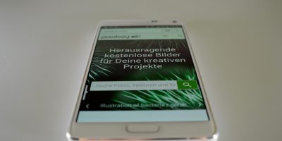 社交媒体用户使用像素画生成器将自拍照转换为像素风格头像，手机屏幕显示转换前后的对比效果